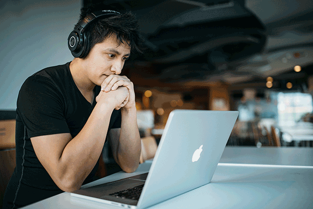 A man with headphones at a laptop